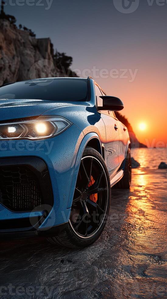 Luxury car parked by the ocean during sunset with vibrant colors reflecting on the sand photo