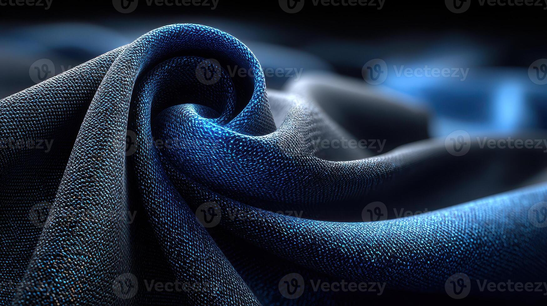 Textured blue fabric creates a wavy pattern in soft lighting with gentle contours and reflections at a close range photo