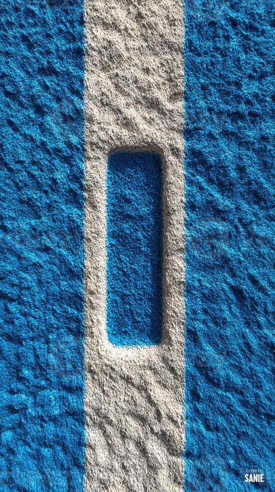 Texture and color contrast of blue and white lines on a surface showing a rectangular indentation in a playground or sports area photo