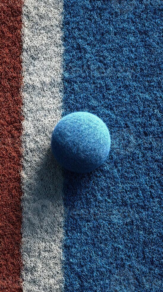 Deep blue textured sphere on a colorful surface representing a sports court during an outdoor game photo