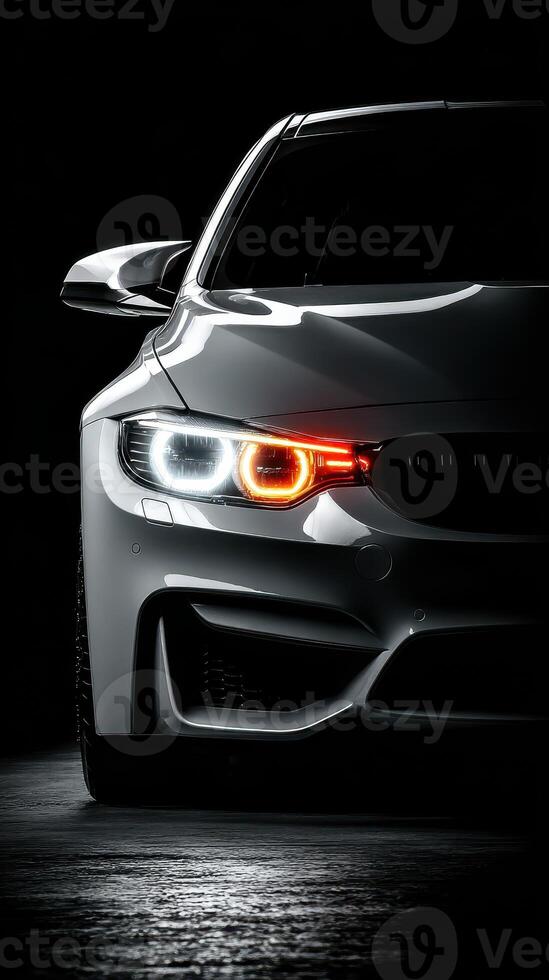 Sleek white sports car with striking headlights illuminated in a dark setting photo