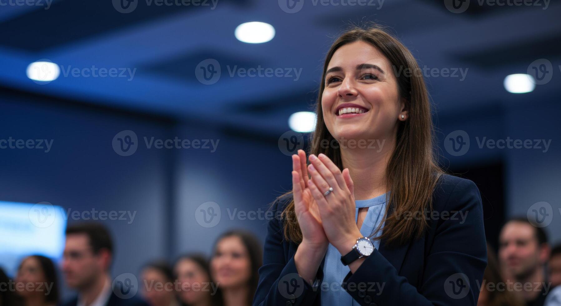 Happy woman clapping and smiling at a business event or meeting photo