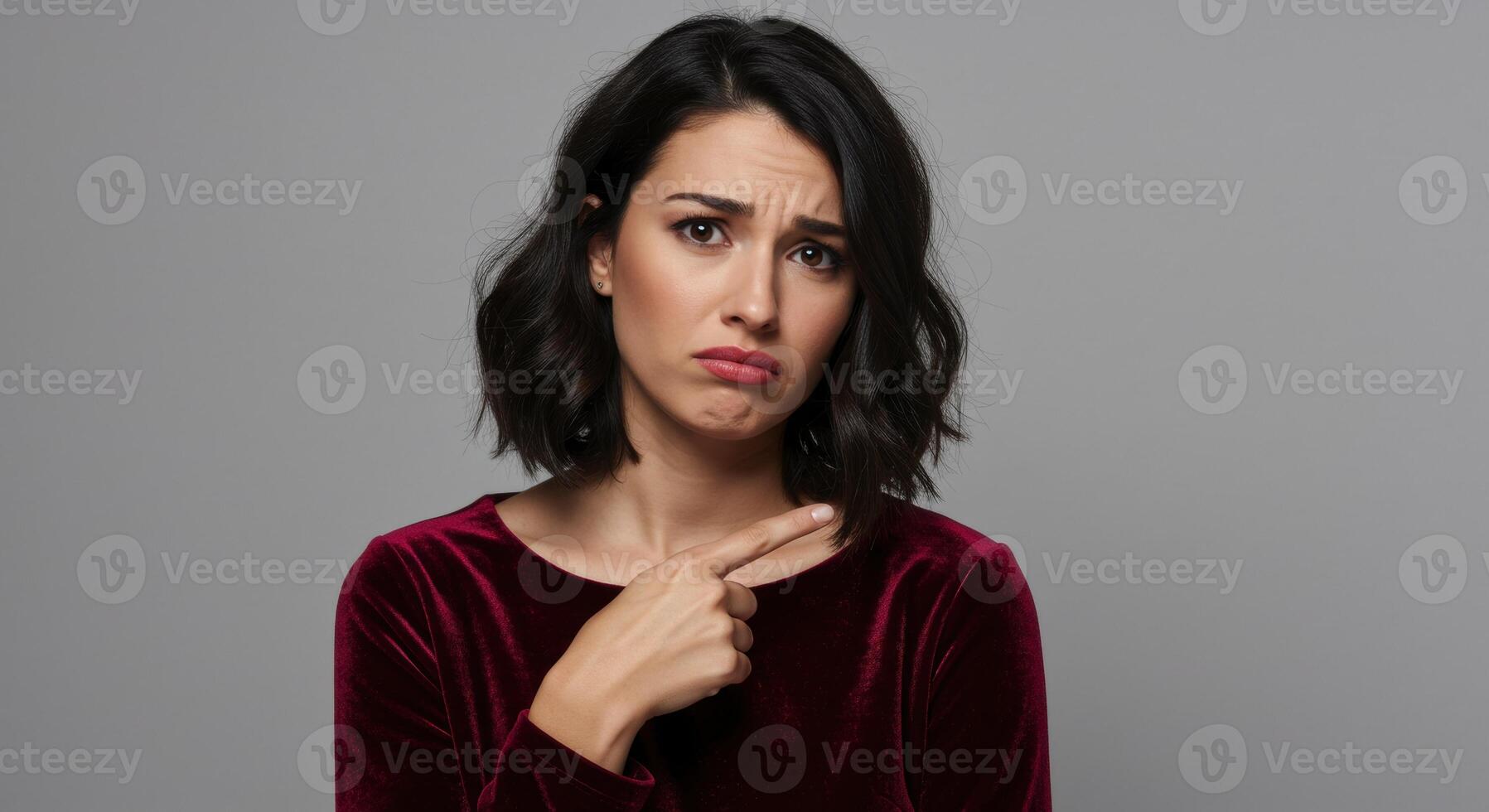 Confused young woman pointing at herself with index finger photo