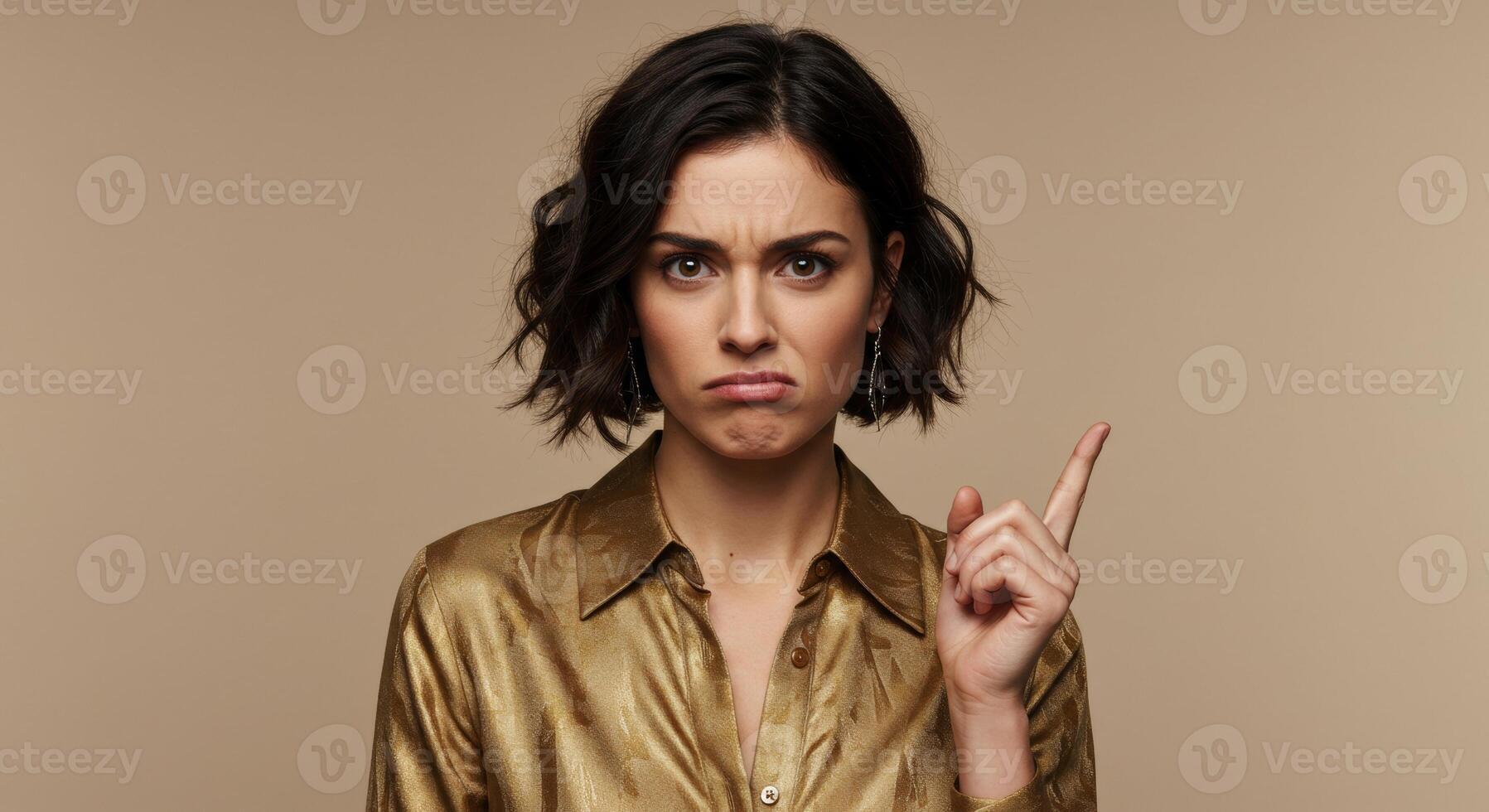 Young woman with displeased expression pointing finger up photo