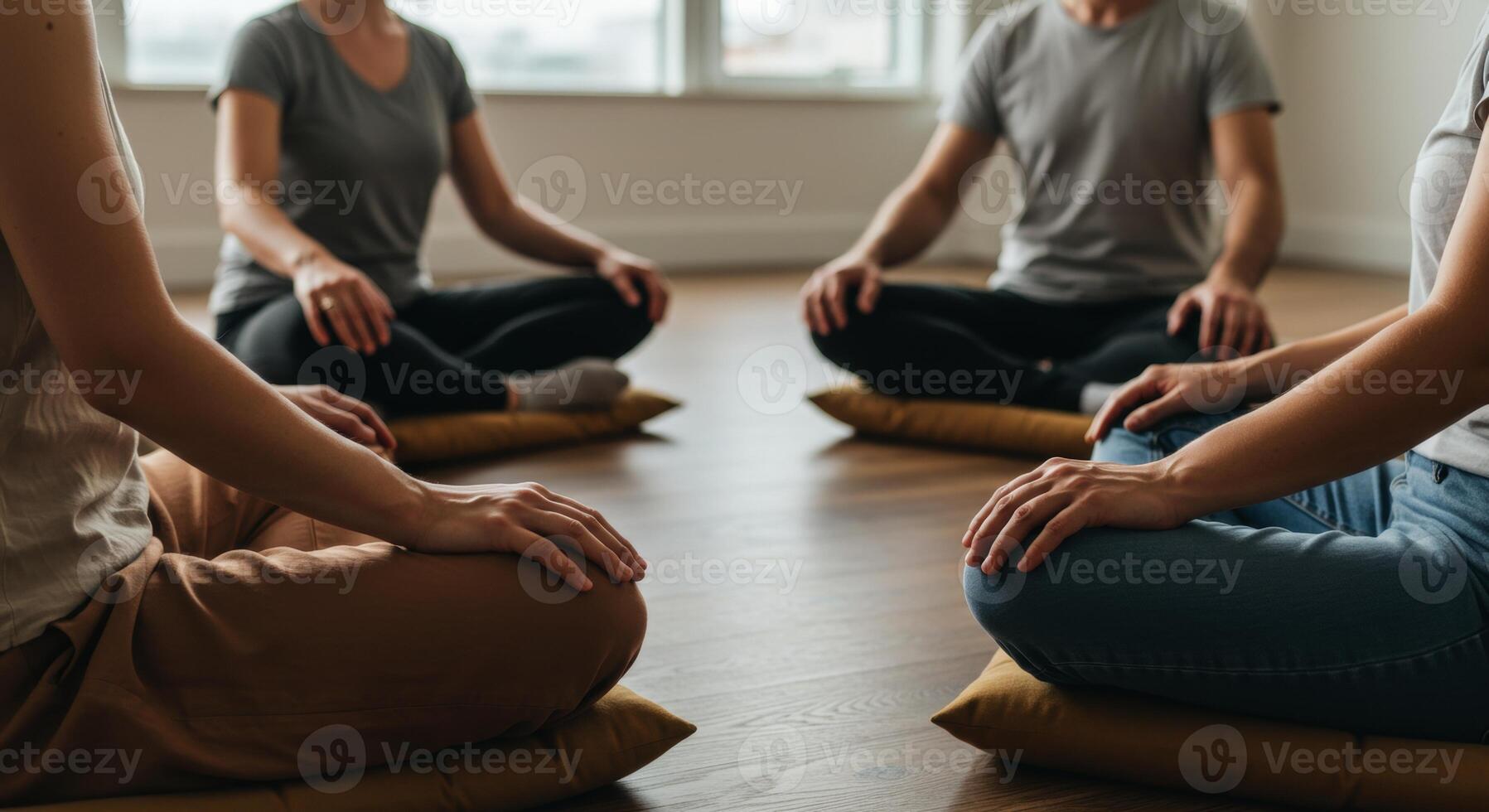 Group meditation session with people sitting in a circle on floor cushions photo
