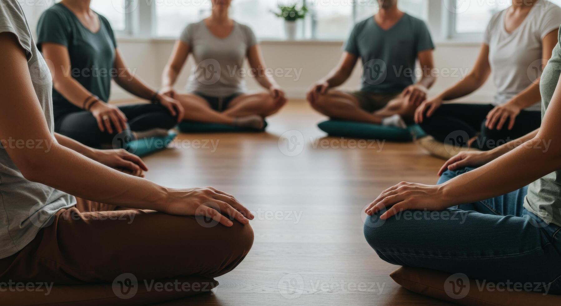 Group of women and men meditating in a circle on the floor photo