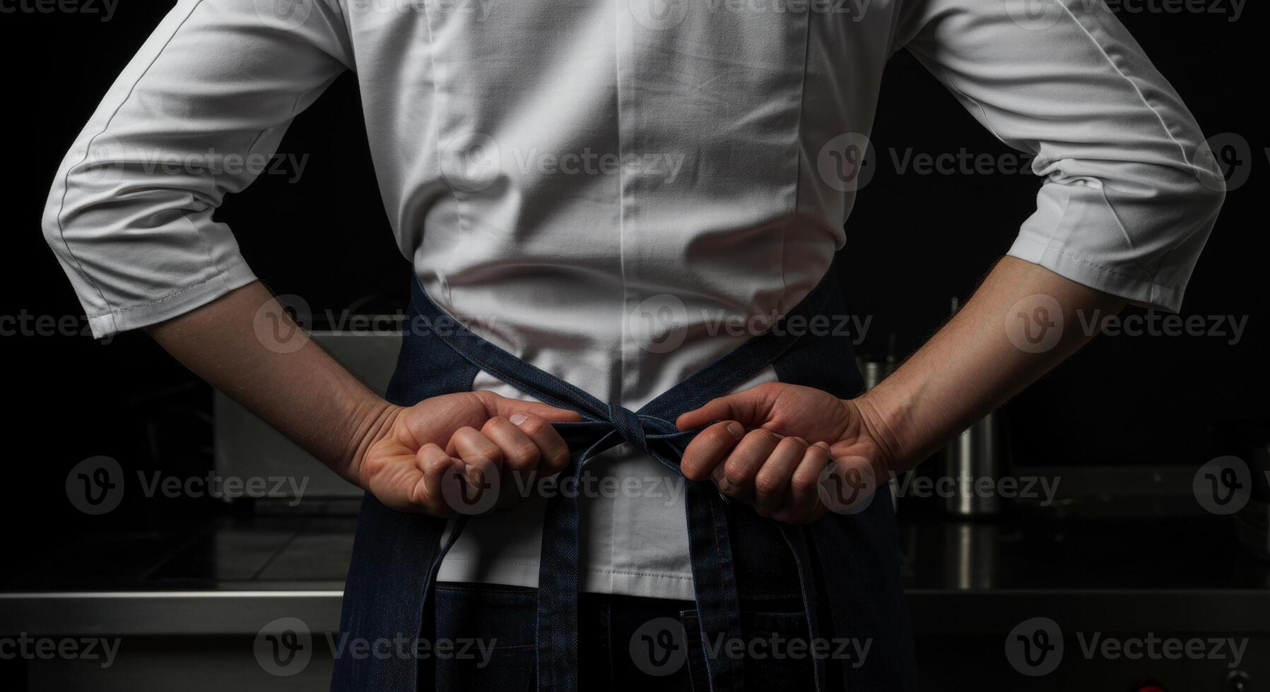 Chef tying apron behind back preparing for work in kitchen photo