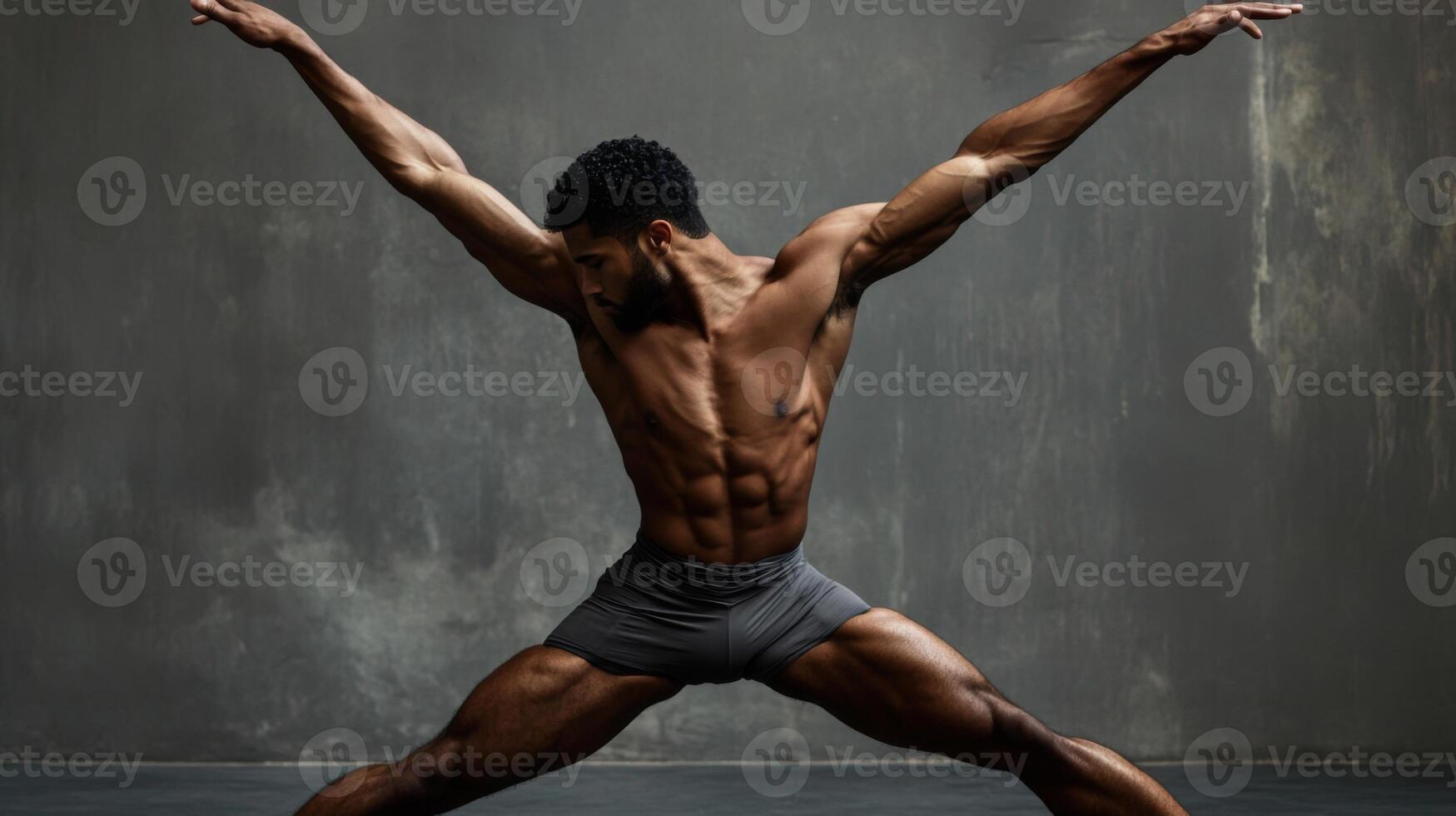 A Muscular Black Man in a Ballet Pose Against a Gray Wall photo
