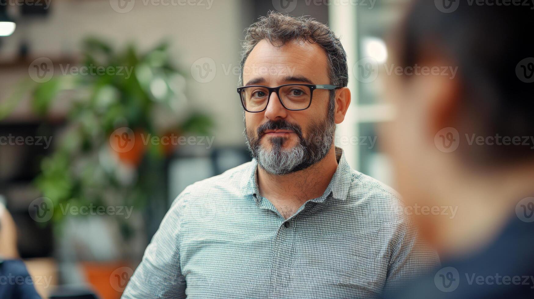 A man with a beard and glasses looking thoughtfully photo