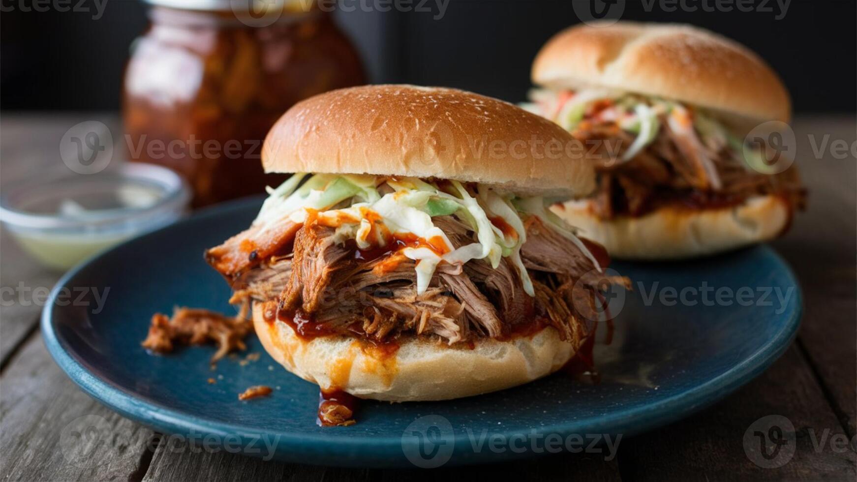 Pulled Pork Sandwich Tender, slow-cooked pork, shredded and mixed with BBQ sauce, served on a bun with coleslaw. photo