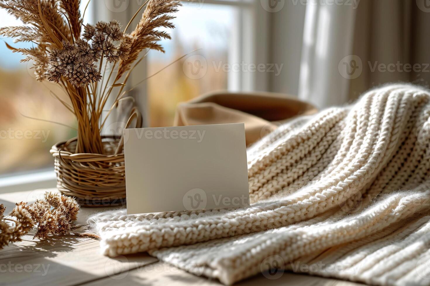 Blank card on a table with a vase of dried grasses photo