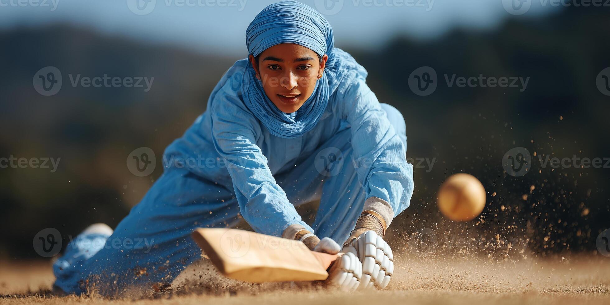Female Indian cricketer executes a spectacular dive for the ball during a live match in a vibrant stadium photo