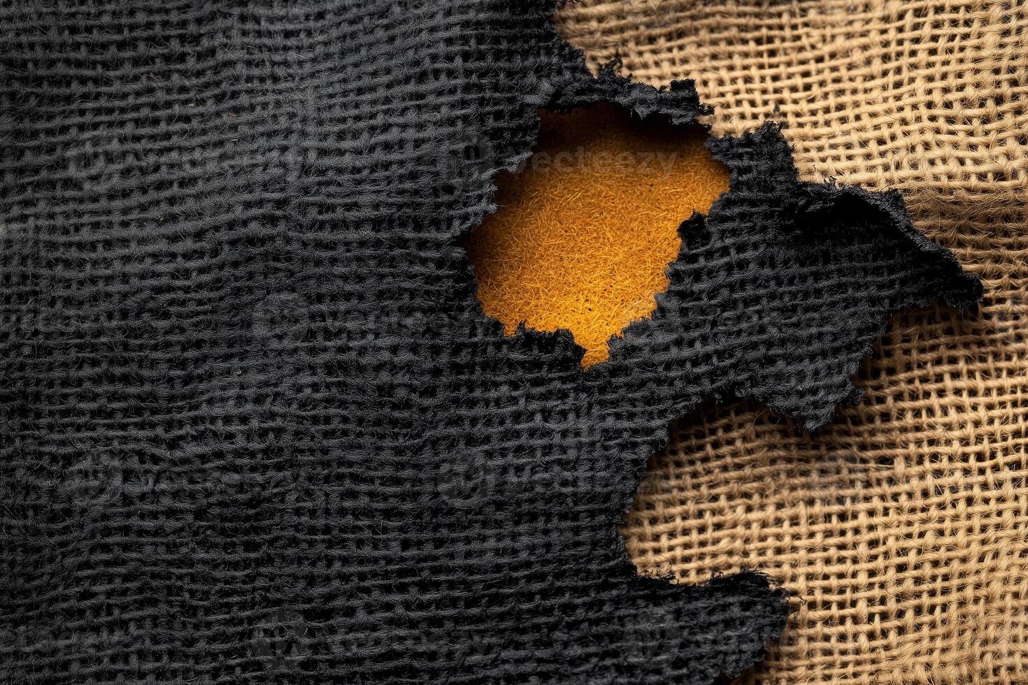 Burnt burlap texture featuring smoldered holes and frayed edges on a surface photo