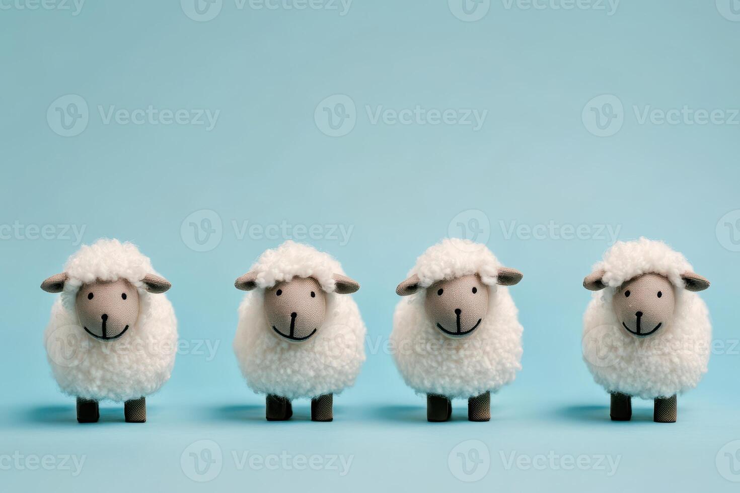 Cute sheep figurines lined up on blue background photo