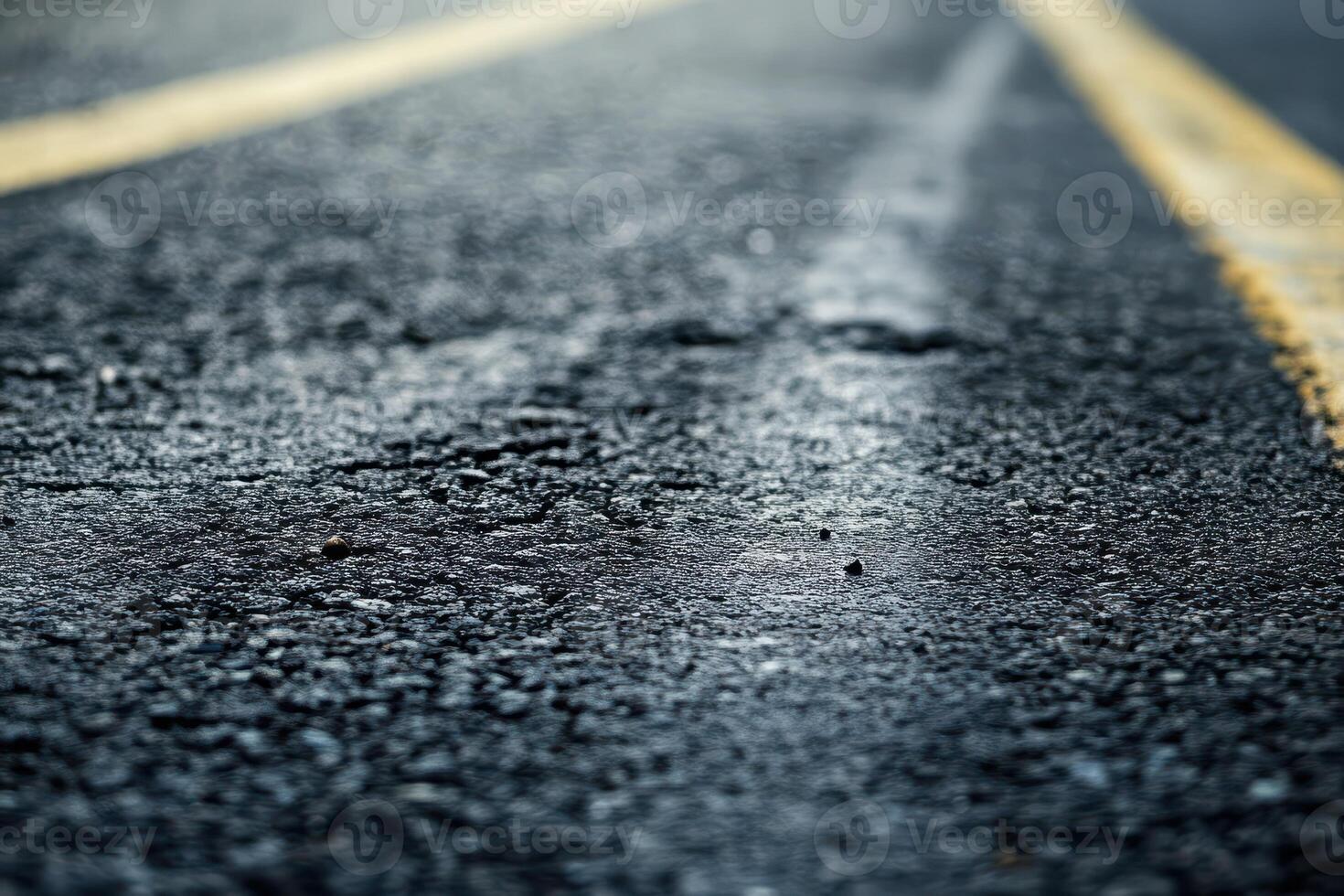 Textured asphalt road surface with yellow stripes photo