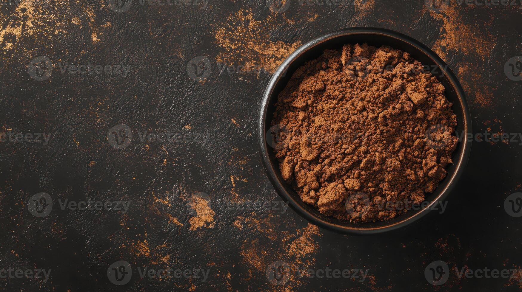 Cocoa powder in black bowl on texture photo