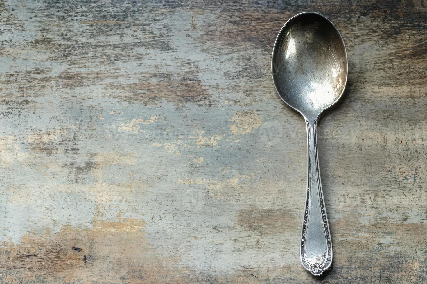 Spoon resting on a rustic wooden surface photo