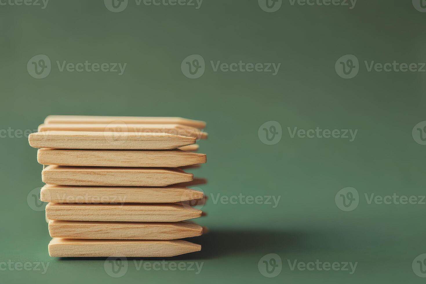 Wooden sticks neatly stacked on a green background photo