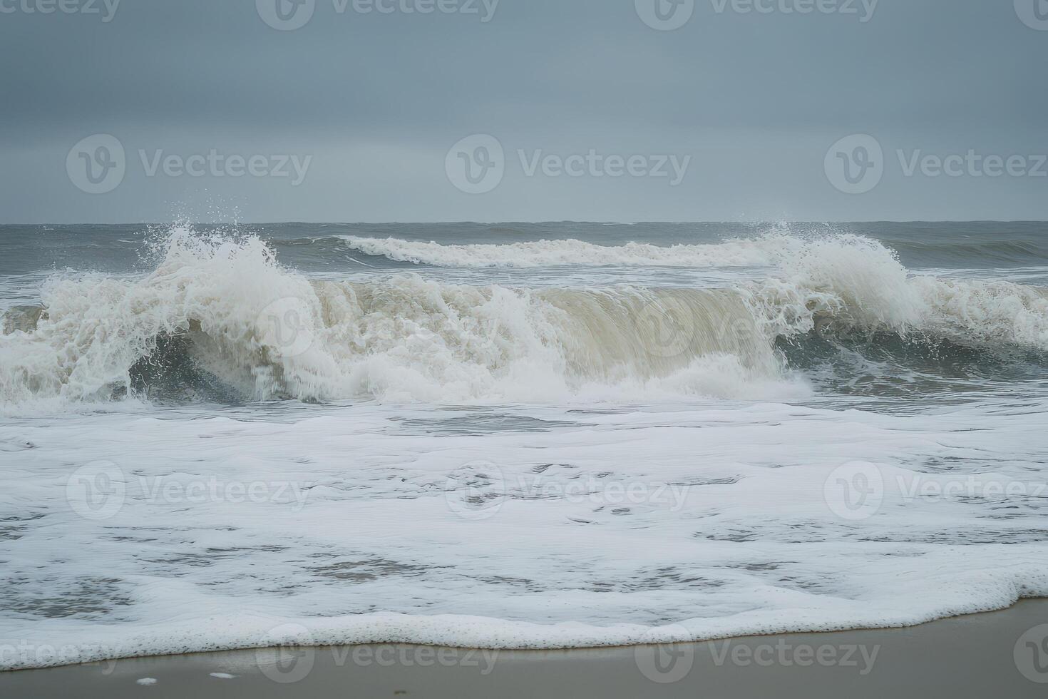 Powerful ocean waves crashing on a sandy shore photo