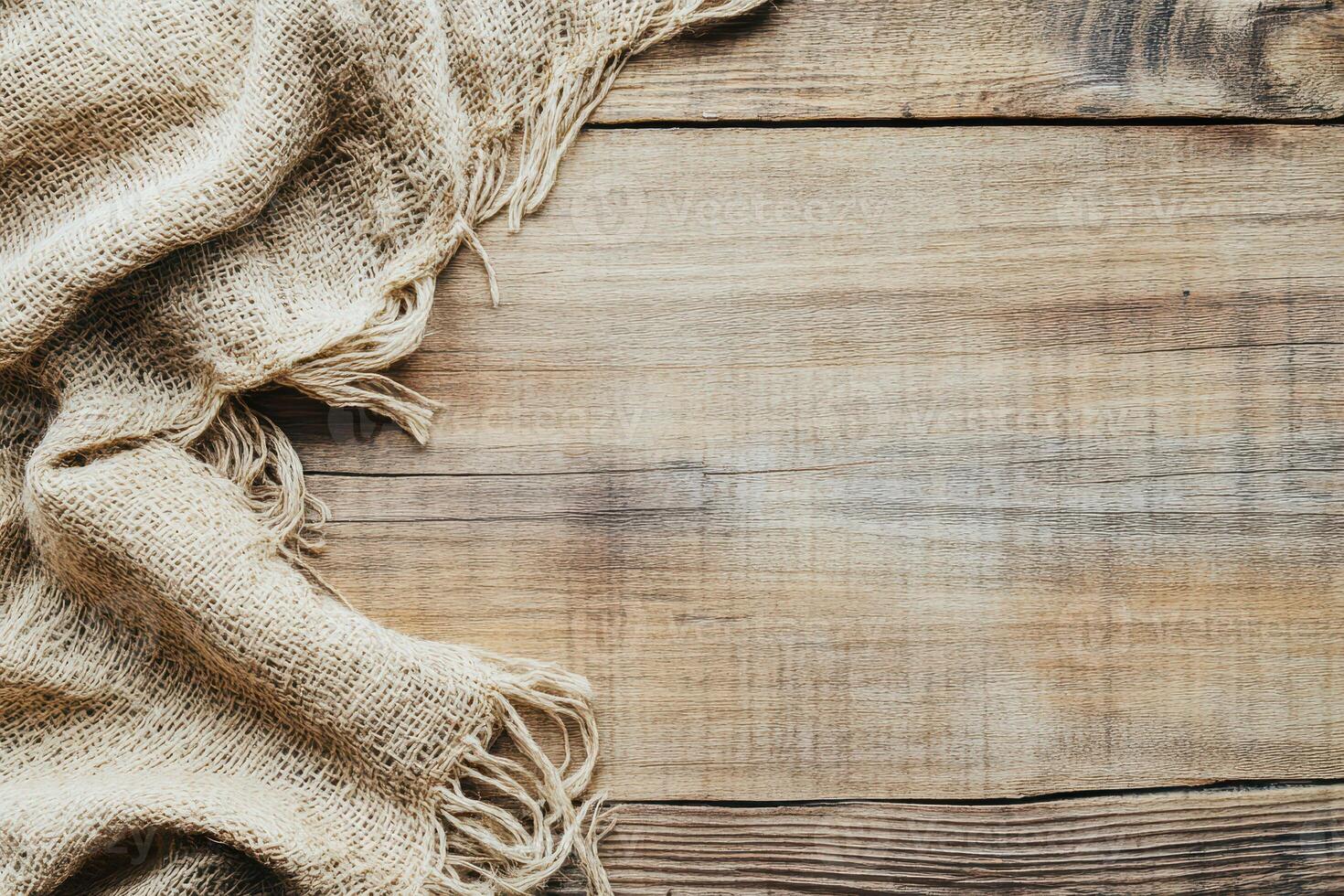 Natural burlap fabric draped on wooden surface photo