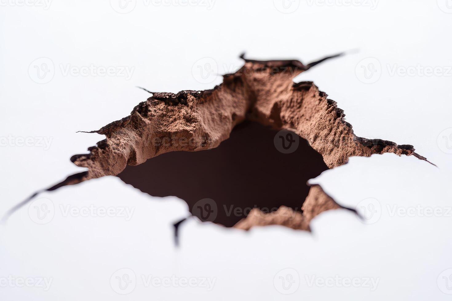 Rough edged hole in white surface photo