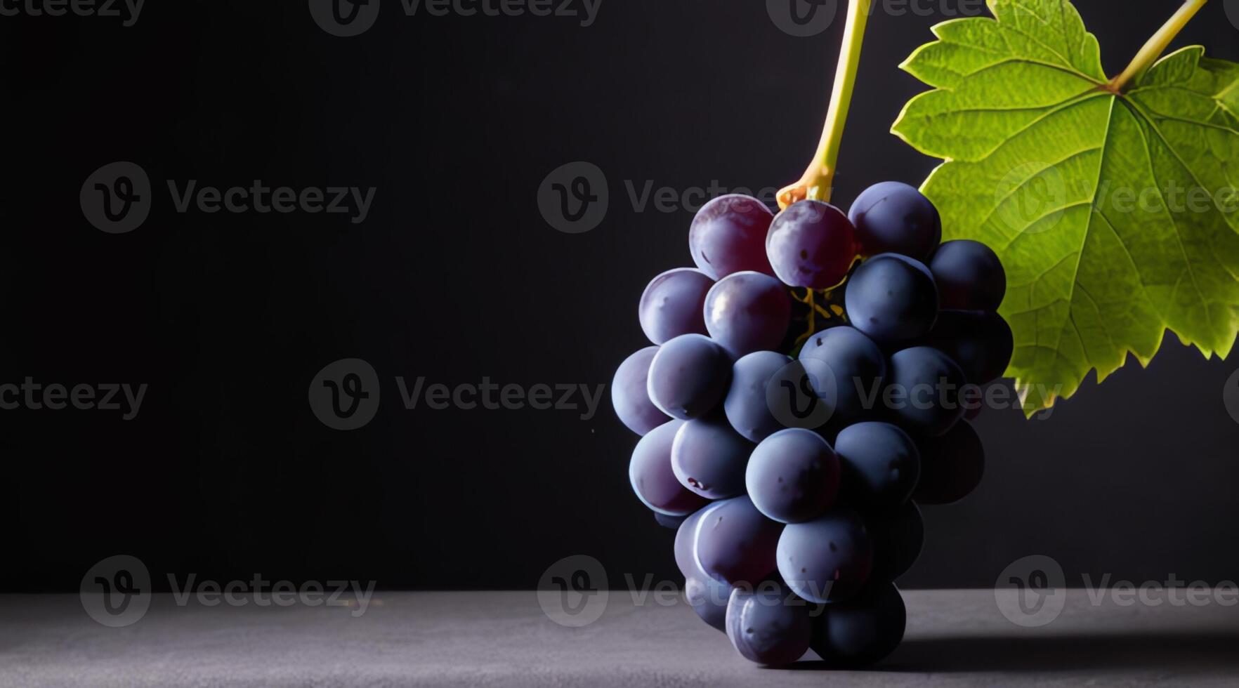 Bunch of grapes with leaf presented on dark background with copy space in high definition 4k photo