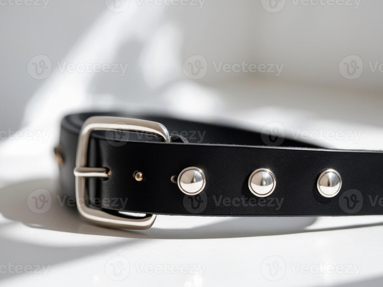 A black leather belt with metal studs photo
