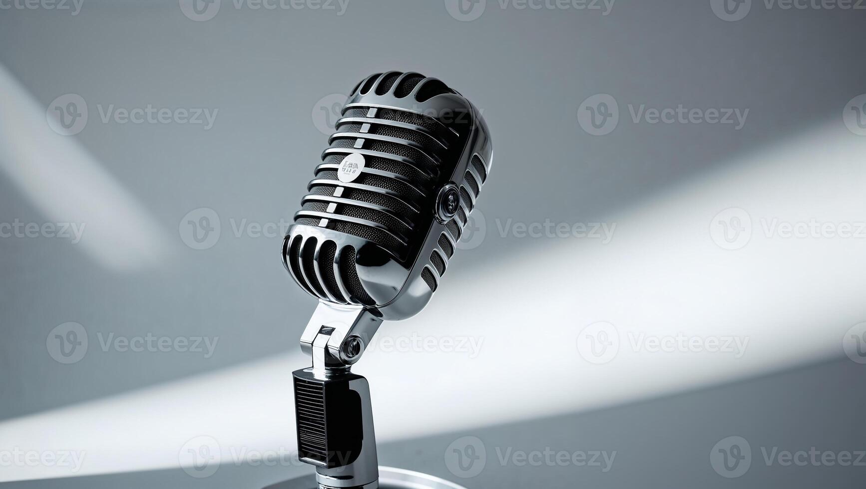 Chrome retro microphone shines under spotlight in gray room photo