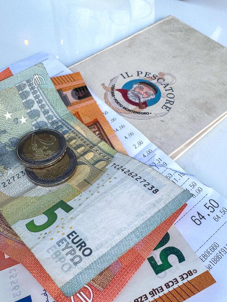 Tivat, Montenegro - April 25, 2025. a check with money on the table at Il Pescatore cafe in Marina Porto Montenegro photo