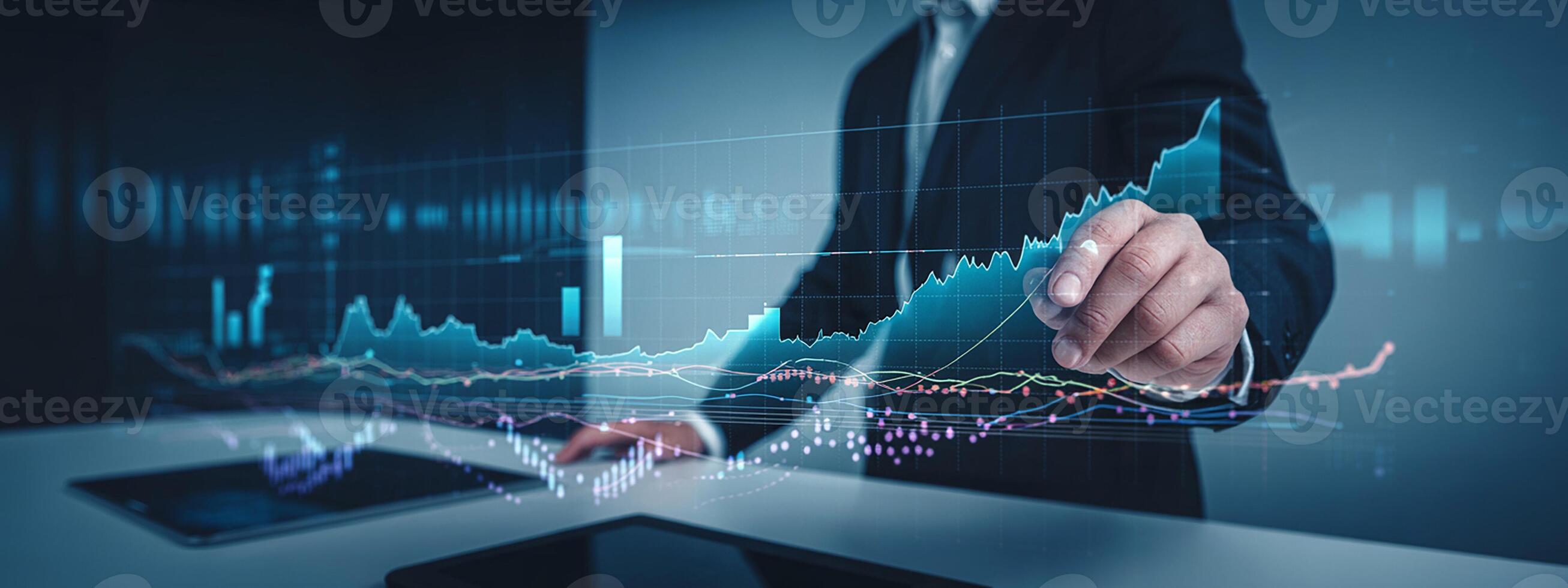 Businessman pointing at graphs on a tablet photo