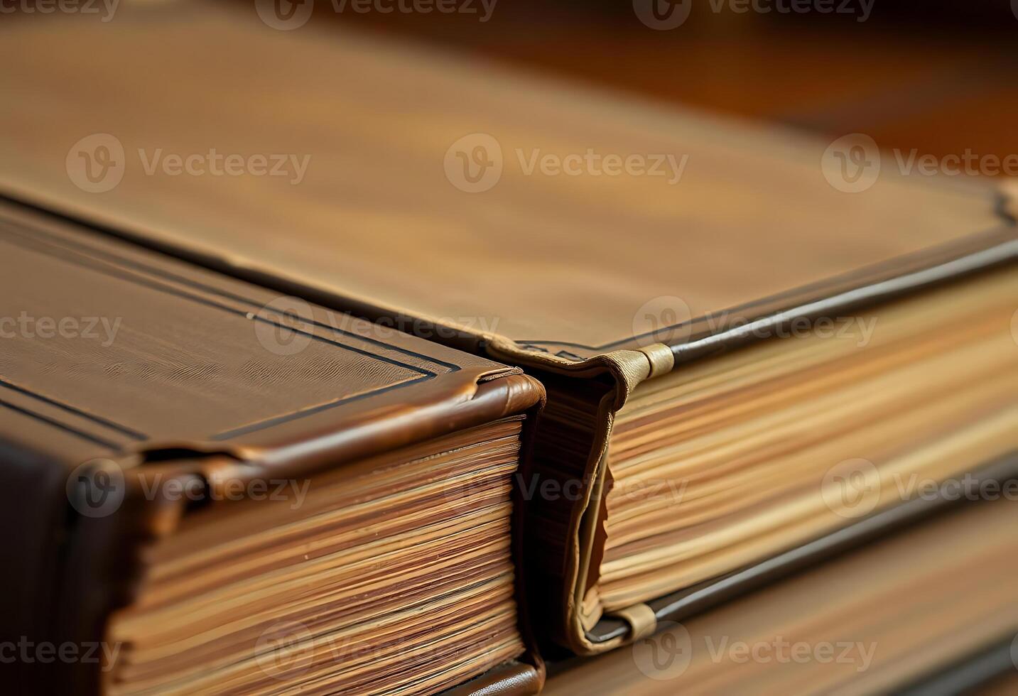 stack of brown books sitting on top of a wooden table photo