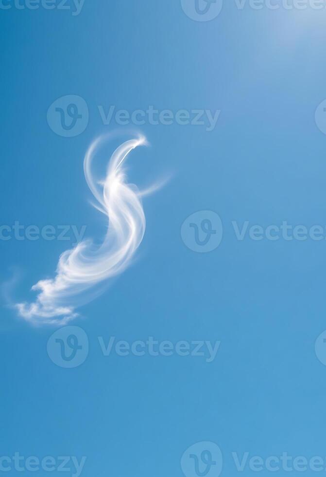cloud shaped like a bird flying through a blue sky photo