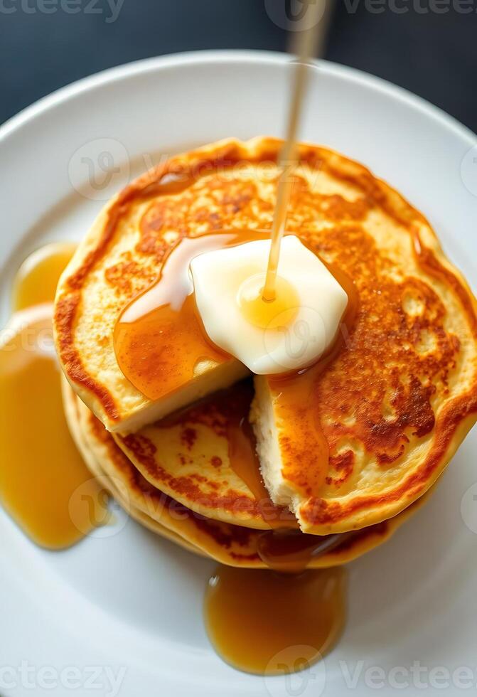 stack of pancakes on a white plate with syrup photo
