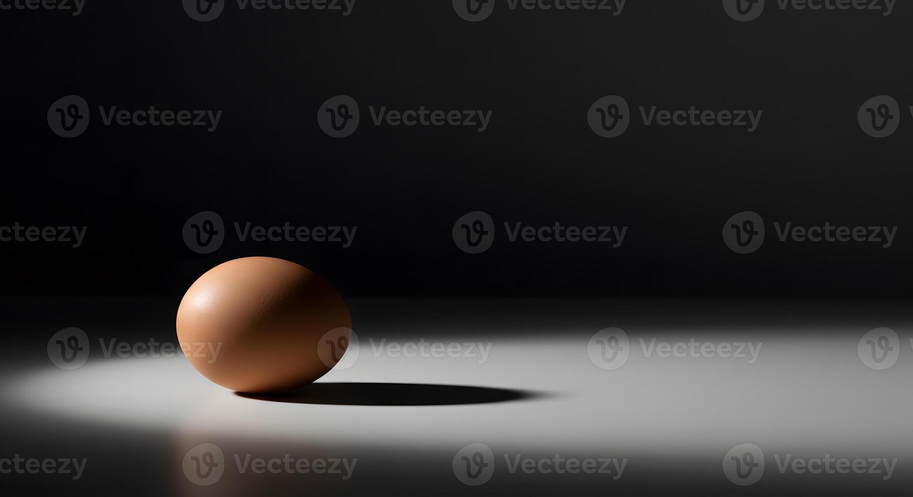 An egg is sitting on a table in front of a black background photo