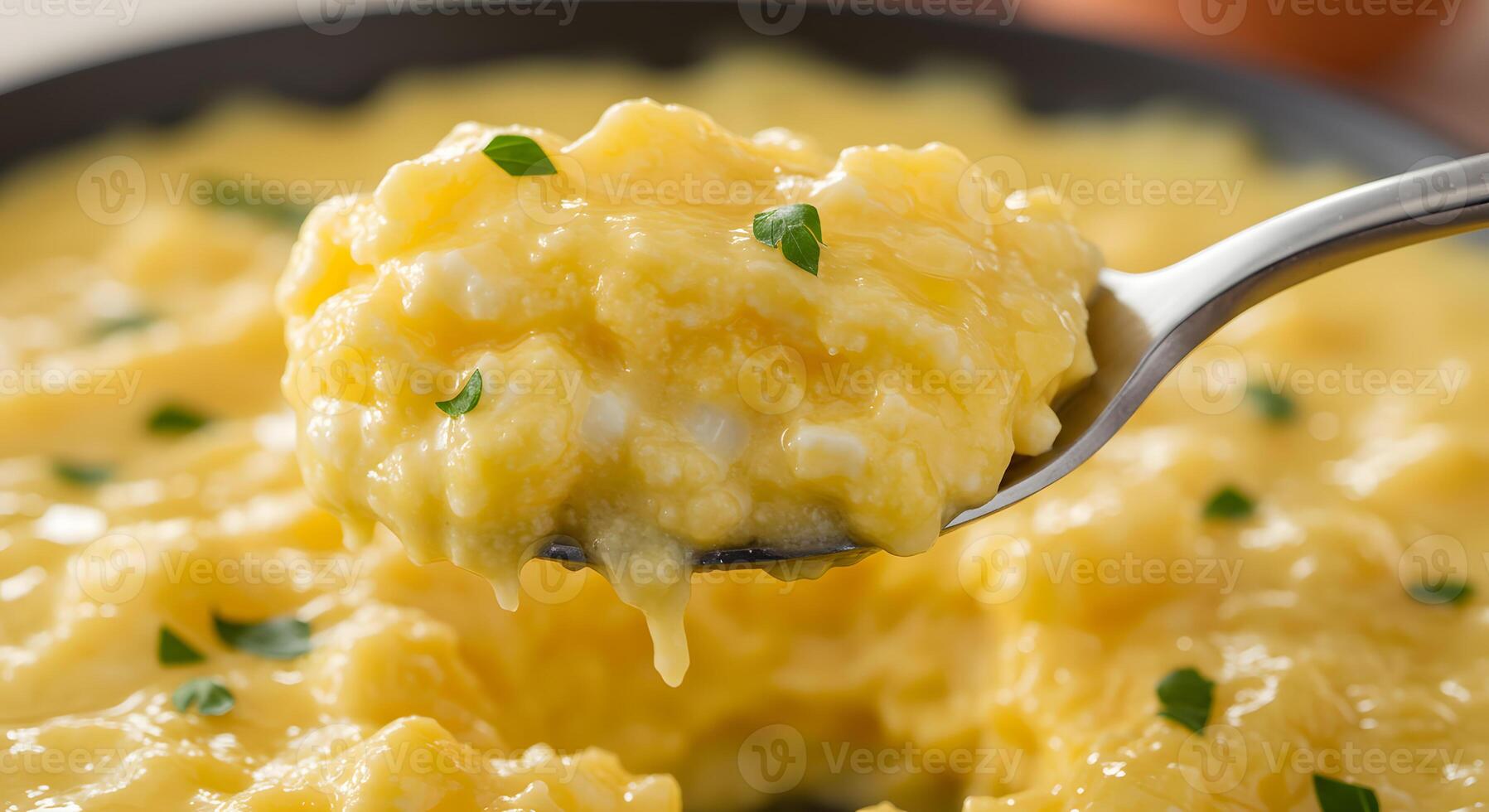A spoon with a scoop of scrambled eggs on it photo