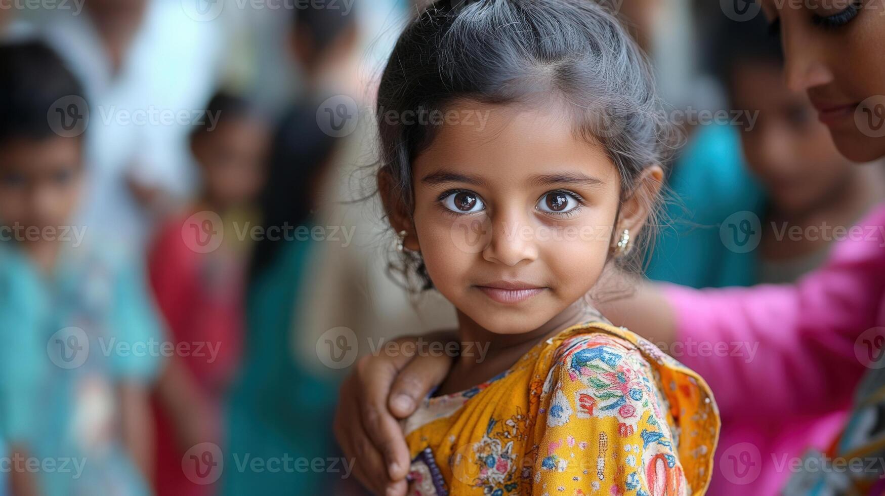 A beautiful Indian girl with captivating eyes and a tender smile held in the arms of another. photo