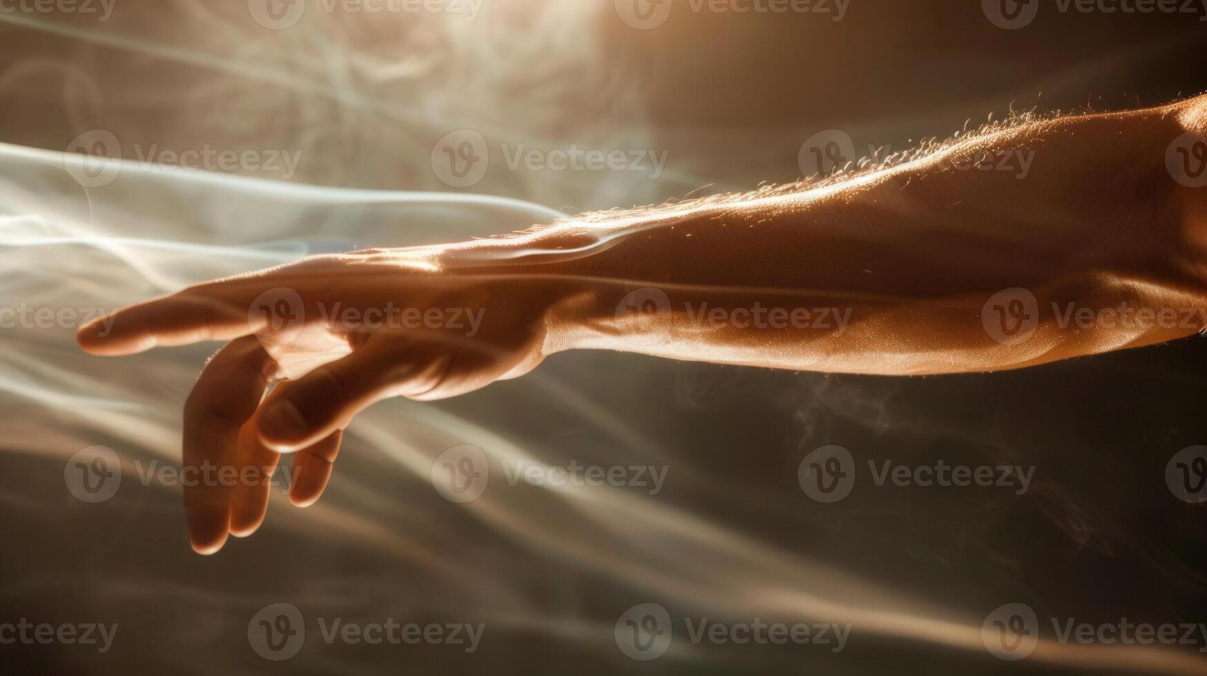 A human hand outstretched, bathed in warm sunlight with flowing smoke, creating depth. photo