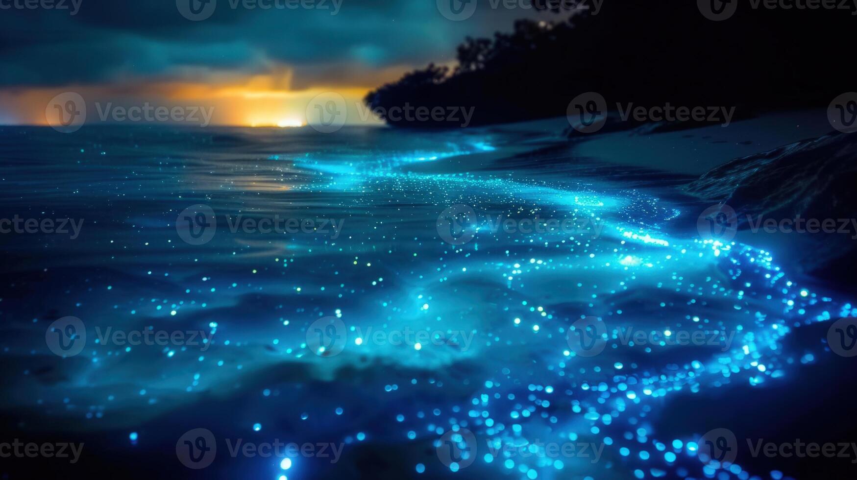 A serene coastal scene showcasing a glowing bioluminescent ocean at twilight, creating a magical atmosphere. photo