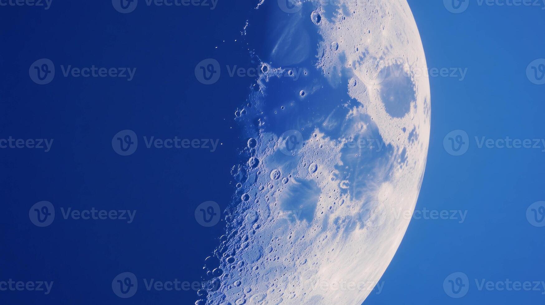 Indigo moon with chaotic texture against a deep blue sky photo