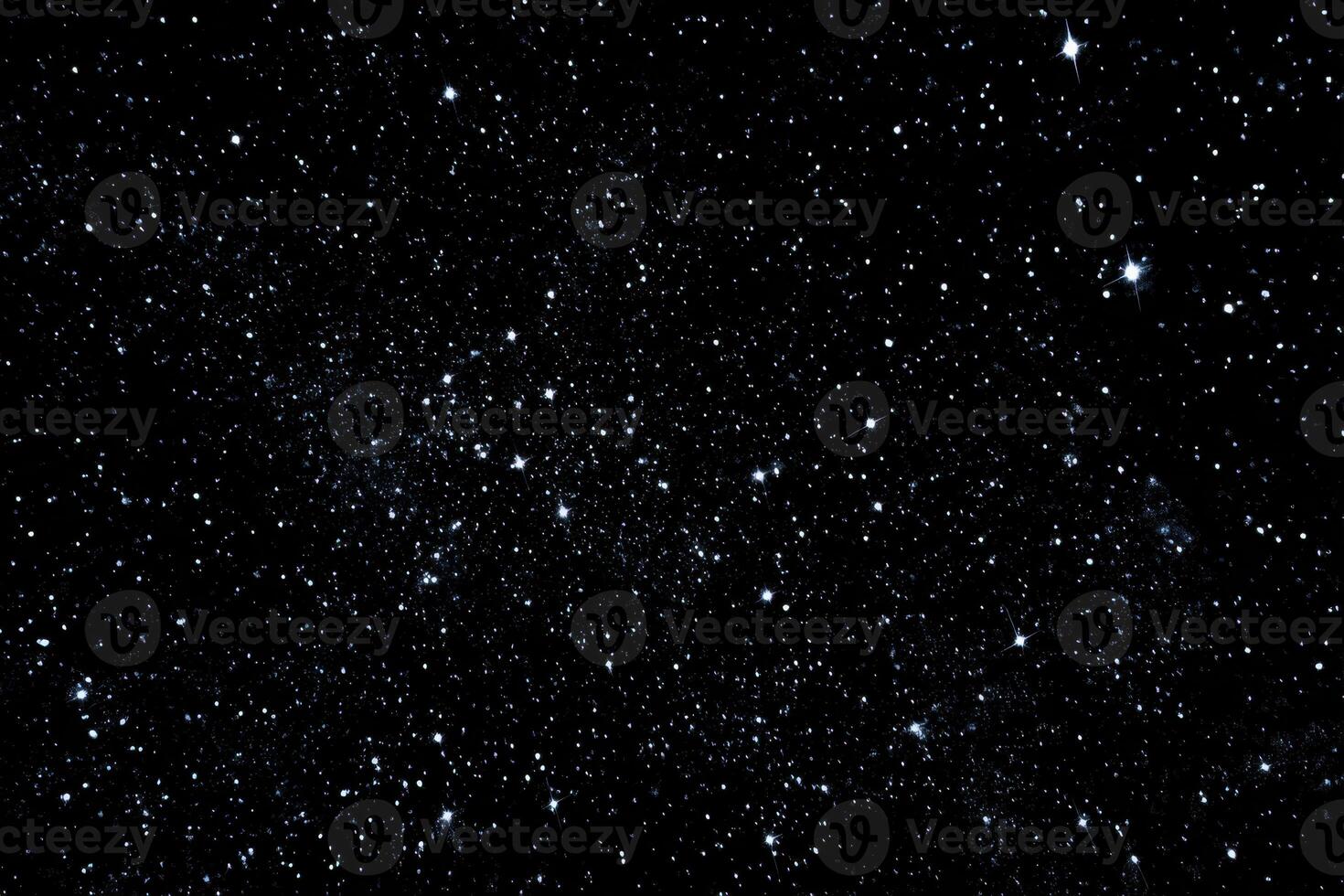 A black sky with stars and some small white dots photo
