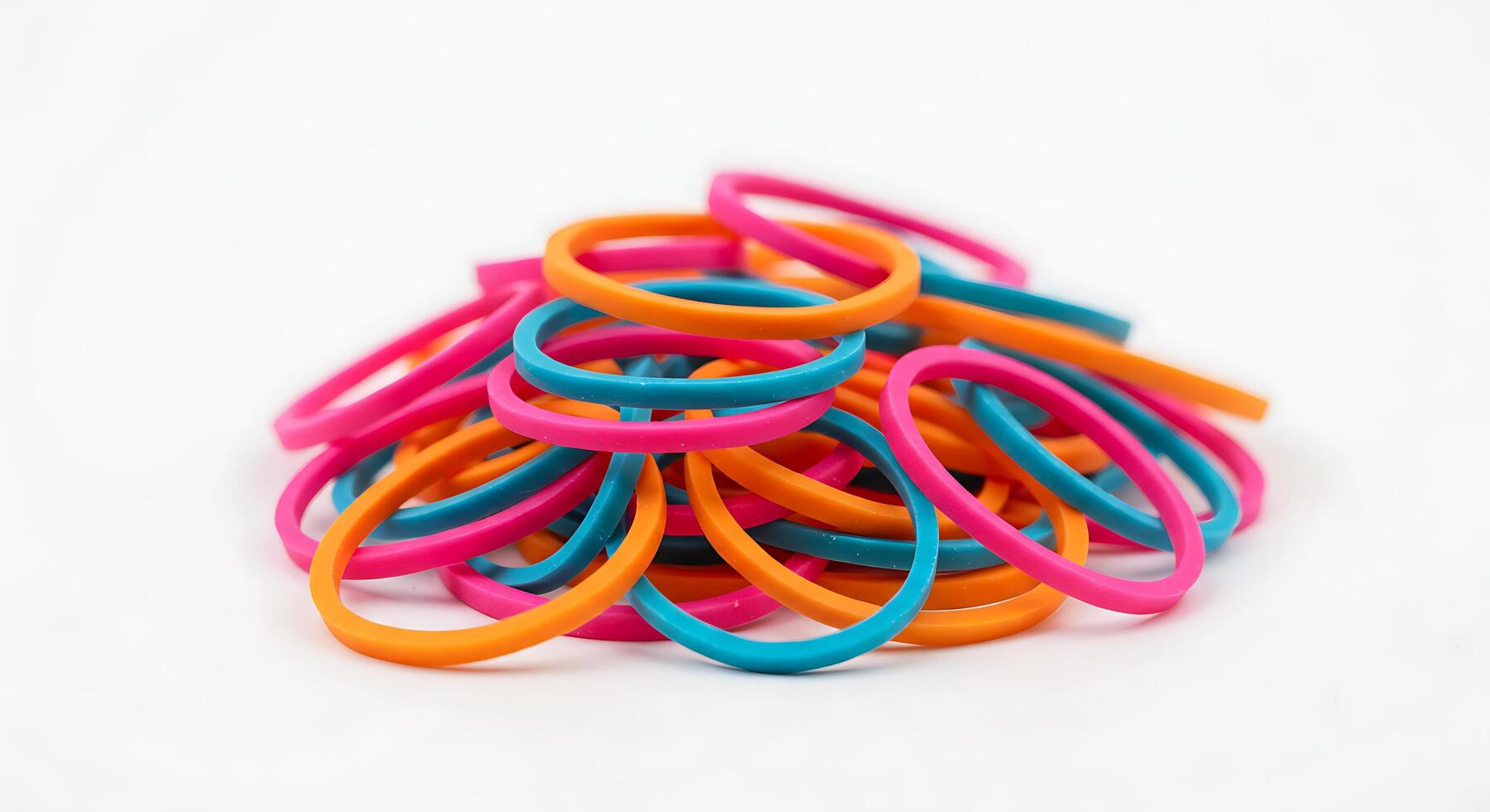 A pile of colorful rubber bands on a white background photo