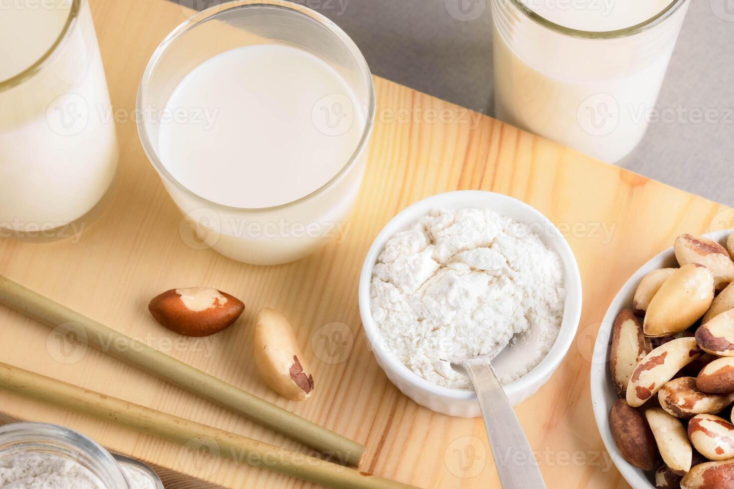 Brazil nut milk and powder displayed on wooden surface with natural textures and elements photo