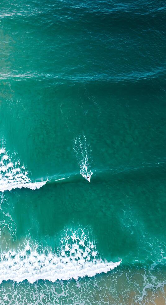 A person is riding a surfboard in the ocean photo