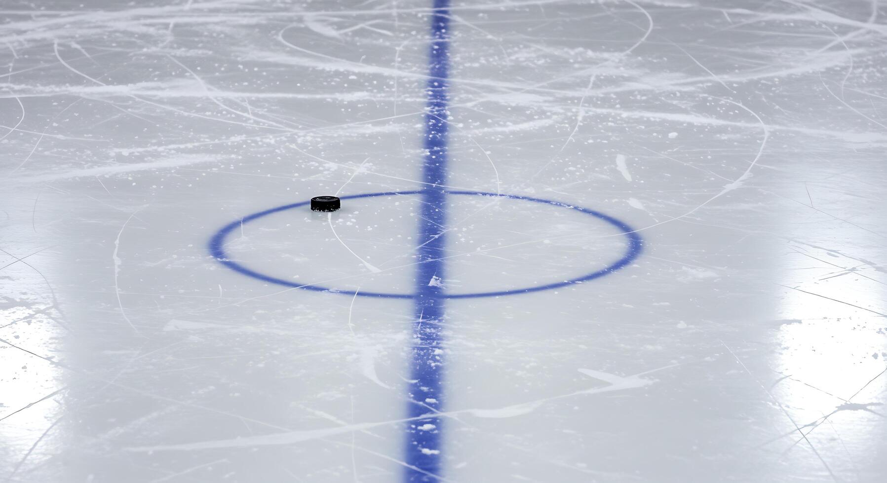 An ice hockey rink with a puck on the ice photo