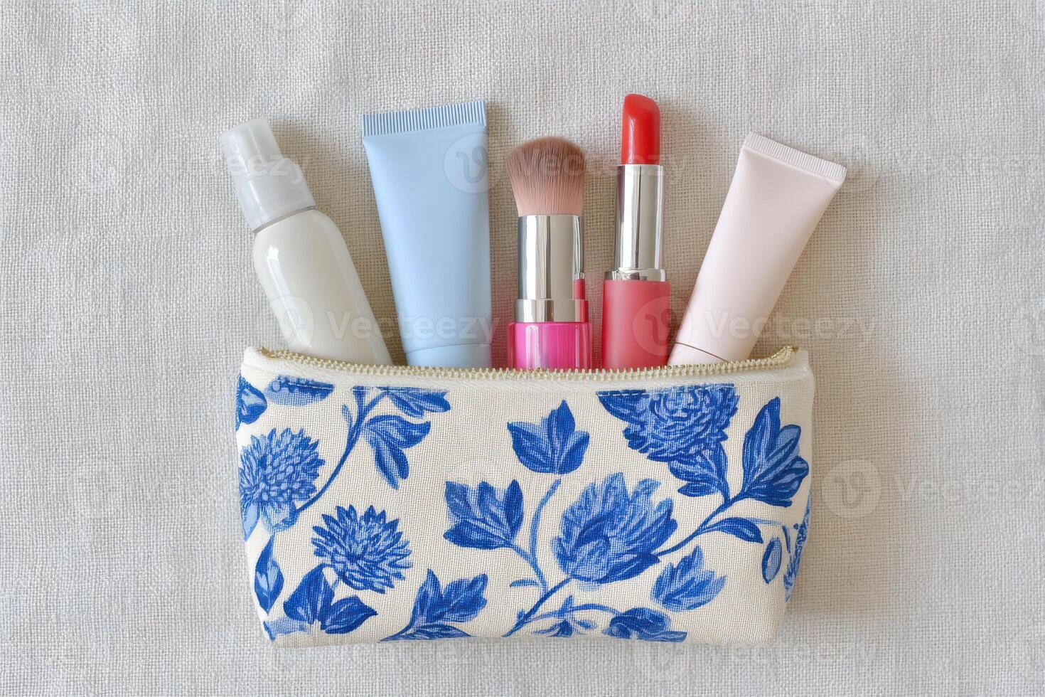 Cosmetic pouch filled with various beauty products including lipsticks, creams, and sprays, showcasing vibrant colors and floral design, perfect for makeup enthusiasts and personal care photo