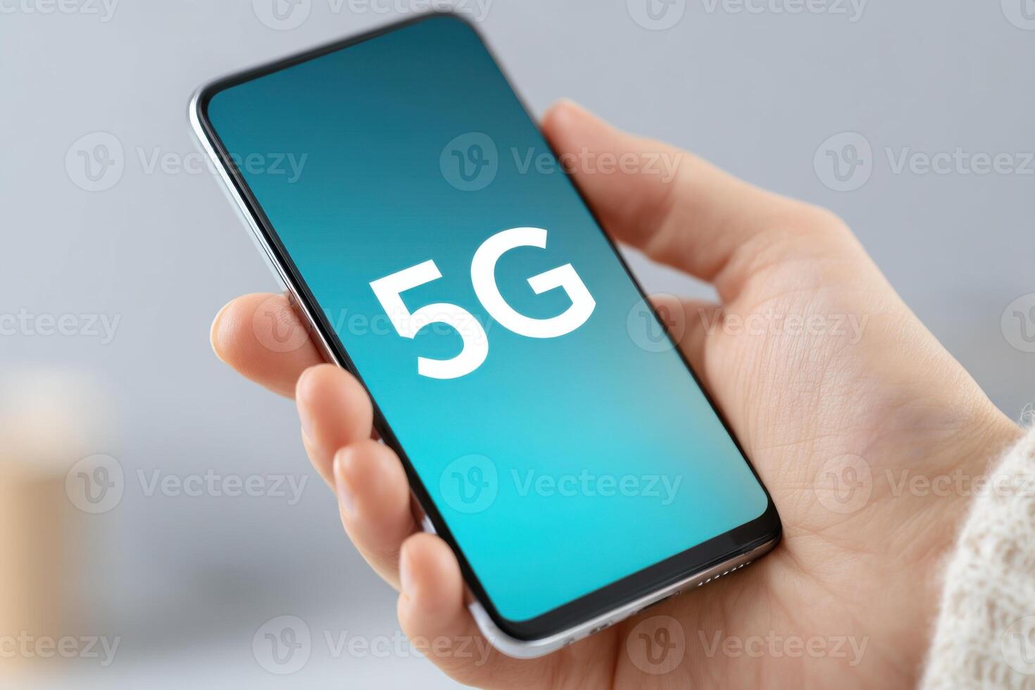 Woman holding smartphone with 5G network icon on screen photo