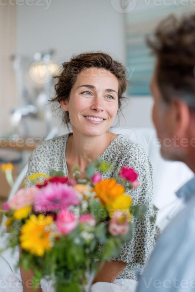 Smiling woman with a bouquet of colorful flowers, sitting in a bright room, engaging in conversation, radiating warmth and joy in a cozy atmosphere of connection and happiness photo