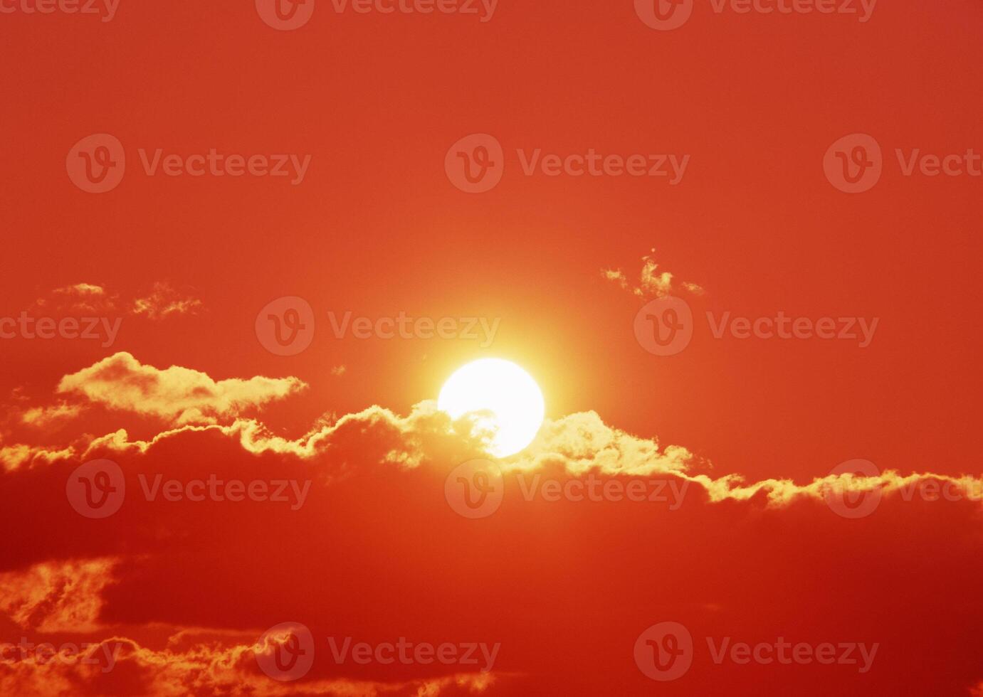 The sun is shining brightly through a cloud covered sky photo