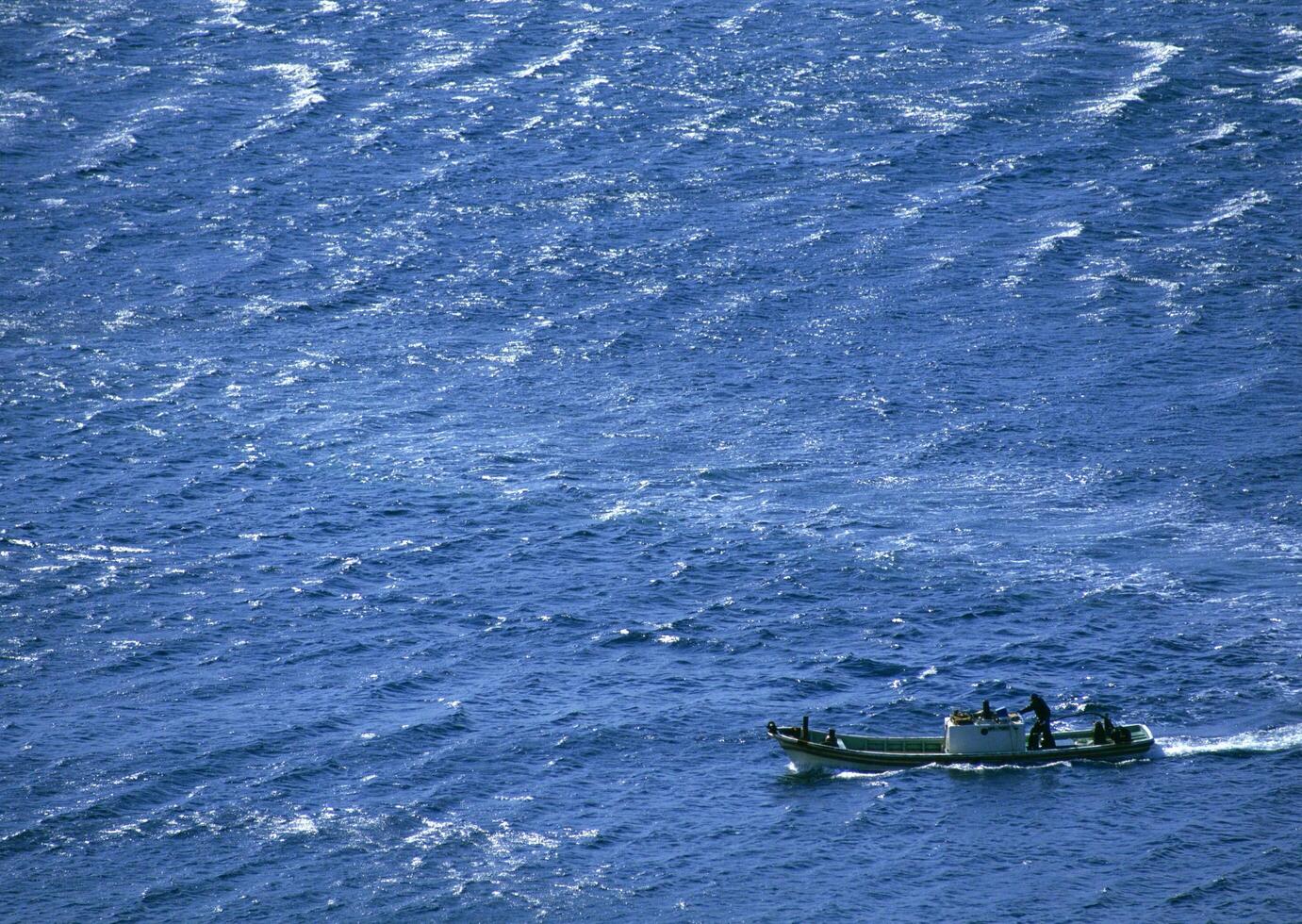 A small boat in the middle of the ocean photo