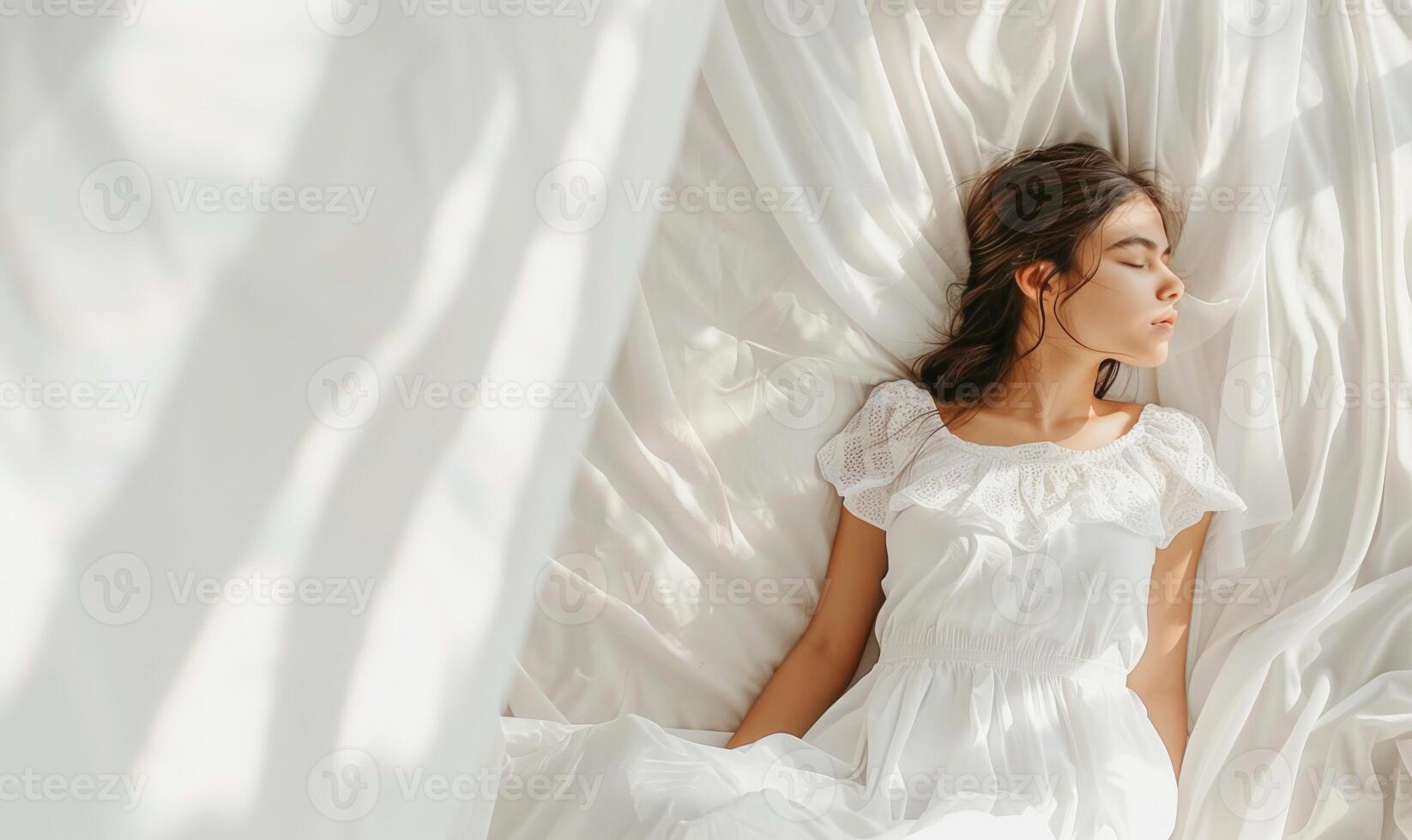Girl peacefully sleeping on white bed with flowing curtains in natural light photo